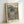 A framed poster print featuring black polka dots of varying sizes on cream background with wavy lines cutting through the pattern. The top displays "YAYOI KUSAMA" and "KYOTO 1998" in bold black text, with "MUSEE D'ART MODERNE DE LA VILLE DE PARIS" at bottom. The artwork is displayed in a light wood frame leaning against a white wall on a white surface, creating subtle shadows.
