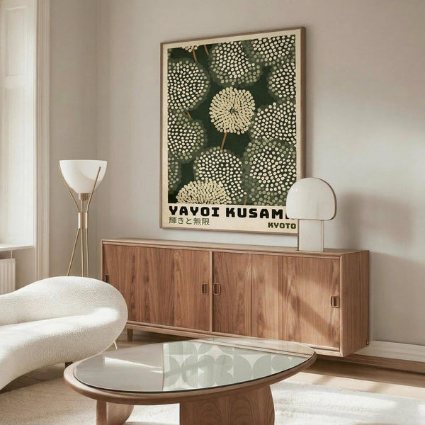 May include: Modern living room mockup showing framed poster with green background and white dotted circular patterns resembling chrysanthemums or dandelions, with Japanese text at bottom. Poster displayed above mid-century walnut credenza alongside brass floor lamp and table lamp. White curved chair and glass oval coffee table complete the minimalist Scandinavian-inspired interior scene.