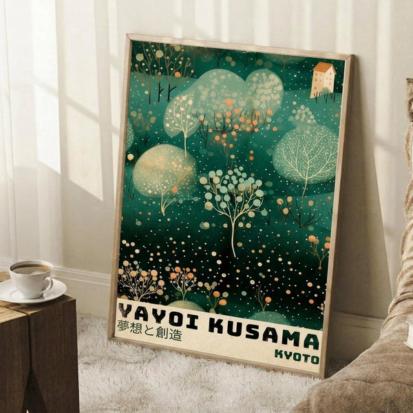 May include: Framed poster with green artistic design featuring stylized trees, polka dots, and botanical elements in an illustrated style. Text reads "YAYOI KUSAMA" and "KYOTO" at bottom with Japanese characters. Poster leans against white wall next to coffee cup on wooden block and cream textured blanket on white fluffy rug.