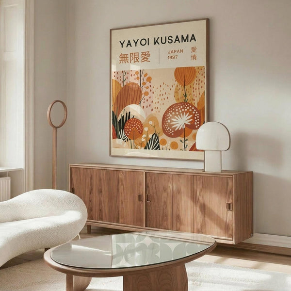 May include: Modern living room scene with framed poster on wall above wooden credenza. Poster features warm orange and cream botanical illustration with mushrooms, flowers, and organic shapes in mid-century modern style. Room includes white curved chair, glass coffee table, floor lamp, and table lamp. Clean minimalist interior with neutral walls and natural lighting.