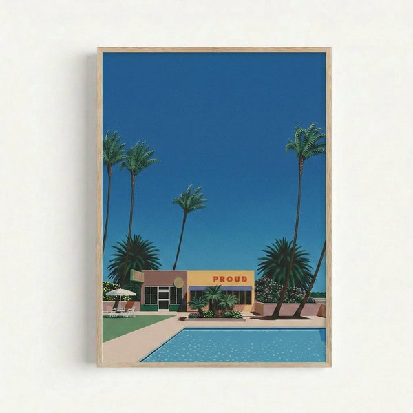 May include: Framed art print in light wood frame hanging on white wall, featuring retro-style illustration of mid-century modern building with "PROUD" text, bright blue swimming pool in foreground, tall palm trees, vivid blue sky, and tropical landscaping in saturated colors reminiscent of 1980s aesthetic