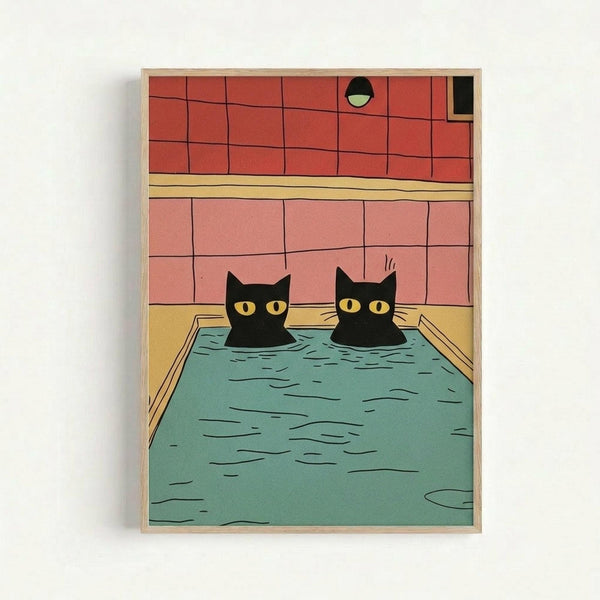 A framed art print showing two black cats with yellow eyes soaking in a turquoise bathtub. The bathroom scene features coral pink tiled walls, a yellow horizontal stripe, and a small circular window. The illustration has a minimalist, cartoon-like style with bold colors and clean lines. The artwork is displayed in a light wooden frame against a white wall.