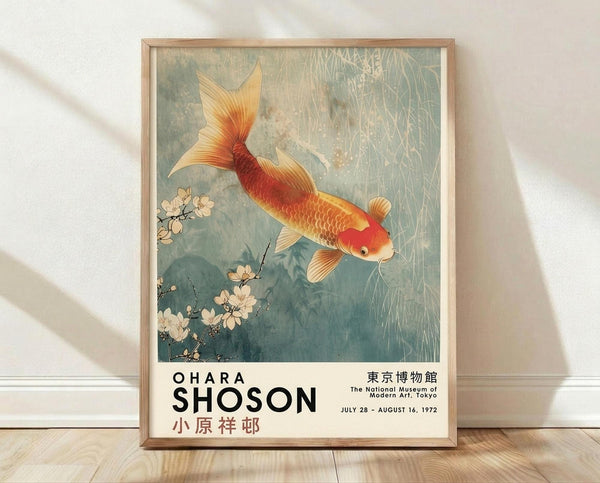 May include: Framed vintage Japanese art poster featuring golden-red koi fish swimming among delicate cherry blossoms in soft blue-green water. Exhibition poster shows "Ohara Shoson" text and Tokyo museum details from 1972. Natural wood frame displayed against white wall with soft shadows on light wooden floor.