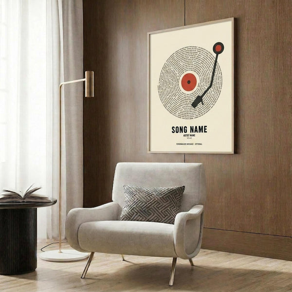 May include: Modern living room with beige upholstered armchair and geometric patterned pillow. Framed poster on wood-paneled wall shows vinyl record design with red center, black tonearm, and text spiraling around the disc reading "Song Name" and "Artist Name." Golden floor lamp and dark round side table with open book visible. Warm wood tones and neutral color palette throughout the contemporary interior space.