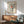May include: Framed poster print featuring a vinyl record design with red center label and black tonearm, displayed above a mid-century modern wood credenza with table lamp. Green upholstered chair with wooden arms sits nearby in minimalist living room with white walls and natural lighting.