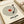 May include: Framed vintage-style poster featuring a cream vinyl record design with red center label and black tonearm. Text spirals in concentric circles around the record, with song title, artist name, and year placeholders below. Print displayed in light wood frame on cream surface with soft natural lighting and neutral background.