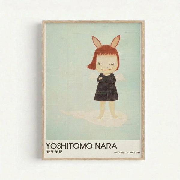 Framed art print featuring a stylized cartoon character with rabbit ears, reddish-brown bob haircut, and mischievous expression wearing a black dress with crossed arms. The figure stands against a soft mint green background with subtle cloud-like textures. Below the artwork is text reading "YOSHITOMO NARA" in bold letters with Japanese characters and exhibition dates from 1992. The print is displayed in a light wooden frame against a white wall.