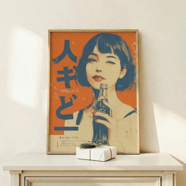 May include: Framed vintage-style Japanese Coca-Cola advertisement poster featuring a woman with dark bob haircut holding a Coke bottle against orange background with blue Japanese text, displayed on light wood console table next to small white wrapped gift with pine sprig, against cream wall with natural lighting