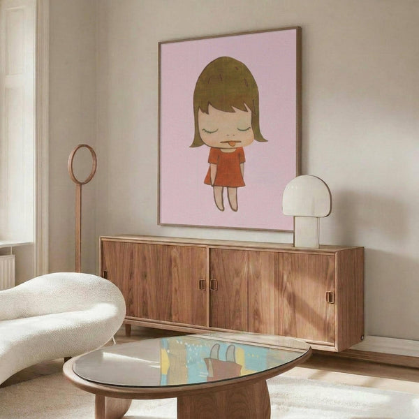 May include: Framed poster with pink background featuring cartoon-style illustration of young girl with brown bob haircut, red dress, and tongue sticking out, displayed above wooden mid-century credenza in modern living room with white curved chair, glass coffee table, and white table lamp