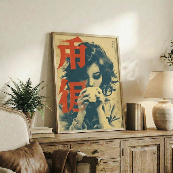 May include: Framed vintage-style poster featuring a woman with tousled dark hair drinking from a cup, rendered in cream, teal and red colors with Japanese characters. Shown leaning against white wall on rustic wooden sideboard alongside potted fern, books, and ceramic vases in neutral-toned living room setting.