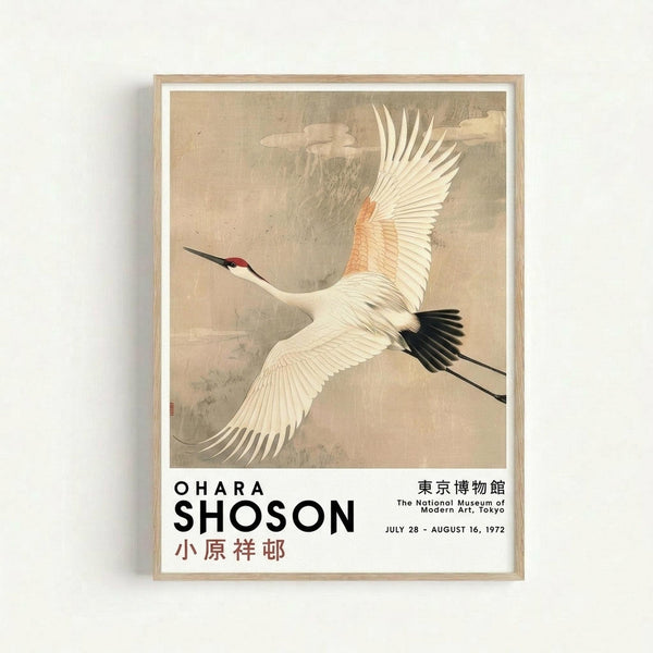 Framed vintage-style Japanese art print featuring a white crane with red head marking and black wing tips flying through a cloudy beige sky. The crane has outstretched wings showing detailed feather patterns in cream and pale orange tones. Below the artwork is text reading "OHARA SHOSON" with Japanese characters and "The National Museum of Modern Art, Tokyo" with exhibition dates "JULY 28 - AUGUST 16, 1972". The print is displayed in a light wooden frame with white matting agai