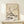 May include: Vintage Japanese art poster in light wood frame showing white bird perched on flowering cherry blossom branches against cream background. Exhibition poster features black text for Ohara Shoson at Tokyo National Museum, July-August 1972. Displayed on light wood shelf with small wrapped gift box, against neutral wall with soft natural lighting.