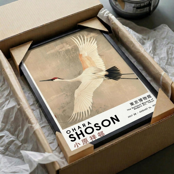 May include: Vintage Japanese art print featuring a white crane with red head cap and black wing tips flying against a muted beige background. The artwork is displayed in a black frame, packaged in brown cardboard with protective wrapping, showing exhibition text from The National Museum of Modern Art, Tokyo. Traditional Asian bird illustration in earth tones.