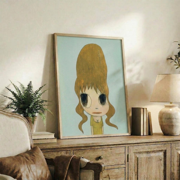 May include: Framed art print featuring anime-style character with golden blonde beehive hairstyle and large dark eyes on mint green background, displayed on rustic wooden sideboard alongside fern plant, books, and ceramic pottery in neutral-toned living room setting with beige sofa and white walls.