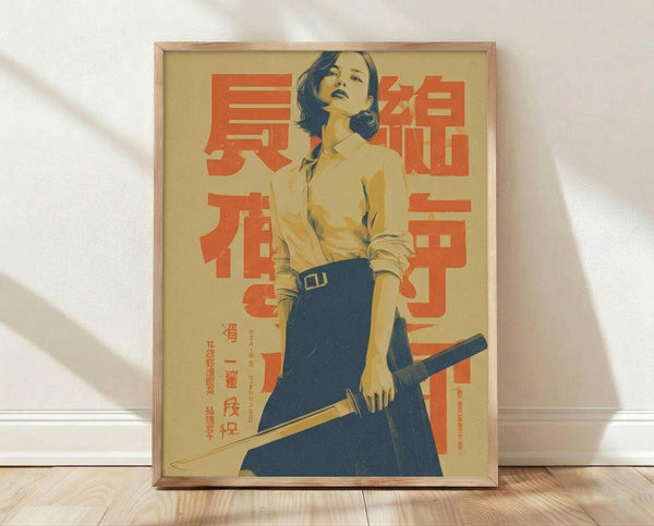 May include: Framed vintage-style poster featuring a woman in yellow shirt and blue skirt holding a katana sword, with large red Japanese characters on beige background. The wooden-framed print leans against a white wall on light wood flooring, with natural window light creating soft shadows across the scene.
