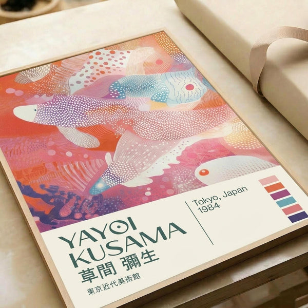 Abstract art poster featuring flowing organic shapes in vibrant coral, pink, blue and orange gradients with white dotted patterns throughout. The design shows fish-like forms swimming in swirling, dreamlike compositions. Text reads "YAYOI KUSAMA" with Japanese characters below, "Tokyo, Japan 1984" in the corner, and includes a small color palette strip. The poster lies flat on white paper with neutral packaging materials visible around the edges.