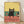 May include: Framed poster print leaning against white wall on light wood floor. Artwork shows black cat with half-closed eyes sitting on coral-pink counter between two wine glasses filled with red wine and dark bottle. Cat has pink inner ears and whiskers with small motion lines. Background features yellow upper wall and teal lower section. Simple illustration style with bold colors in natural wood frame.