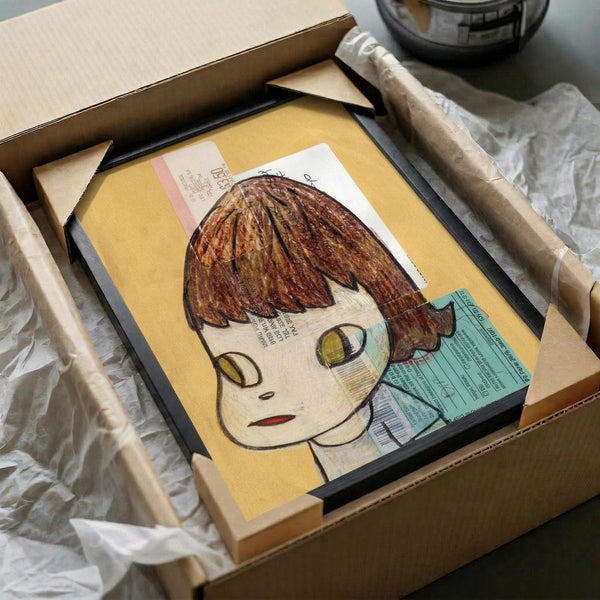 May include: Framed artwork featuring an anime-style girl with brown bob haircut and large eyes on yellow background, displayed in black frame inside cardboard shipping box with protective wrapping materials and wooden support pieces visible around the package.