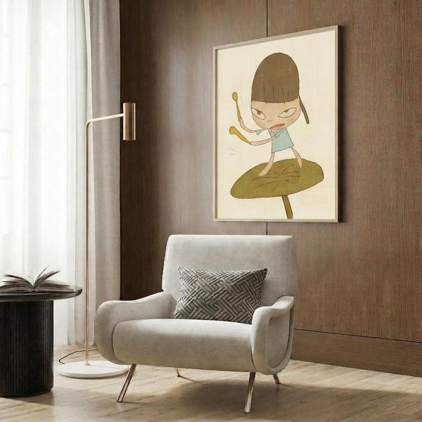 May include: Whimsical illustrated poster featuring a cartoon character with brown bob haircut and light blue shirt standing on a large green leaf, displayed in light wooden frame on dark wood paneled wall above beige upholstered armchair with geometric patterned pillow, brass floor lamp, and dark round side table with open book in modern living room setting.