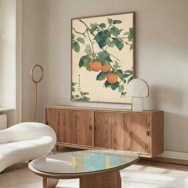 May include: Japanese botanical artwork featuring orange persimmons hanging from leafy green branches on cream background, displayed in thin brown frame above walnut credenza in modern living room with white curved chair, wooden floor lamp, glass coffee table, and neutral decor