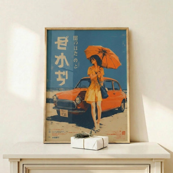 May include: Framed vintage-style Japanese poster featuring woman in orange dress holding matching umbrella beside classic orange car on beach. Blue sky background with white Japanese text. Wooden frame on light wooden shelf with small wrapped gift box. Minimalist white wall setting.