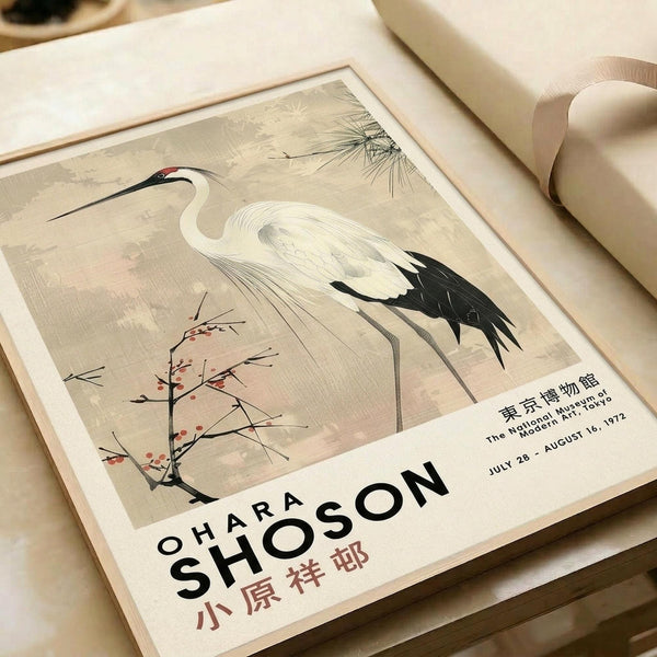 May include: Vintage-style exhibition poster featuring a white crane with black wing tips and long curved beak, standing near delicate flowering branches and pine needles on muted beige background. Text shows "OHARA SHOSON" and Japanese characters, with "The National Museum Tokyo" and exhibition dates "JULY 28 - AUGUST 16, 1972." Poster displayed on neutral surface with cream ribbon beside it.