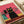 May include: Colorful illustration print displayed on white paper showing stylized cats wearing sunglasses against a pink background. Features a large black cat with yellow sunglasses and collar in center, surrounded by smaller pink and teal cats, all sitting on what appears to be wooden planks. The artwork has a retro, mid-century modern aesthetic with bold colors and geometric shapes.