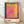 May include: Framed abstract art poster with vibrant pink, yellow, orange, and teal color blocks in Rothko's signature style, displayed against white textured wall on light wood floor. Natural lighting creates soft shadows across the scene. The artwork features bold rectangular forms with painterly edges and rich color transitions.