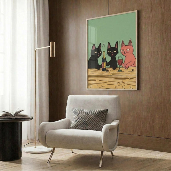May include: Framed poster print showing three cartoon cats sitting at wooden table with wine bottle and glass against mint green background. Print displayed on wood-paneled wall above beige upholstered armchair with geometric patterned pillow. Modern living room setting with gold floor lamp and dark side table.