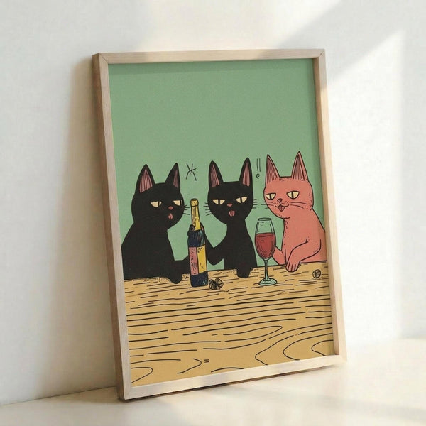 May include: Framed poster print leaning against white wall showing three stylized cats sitting at wooden table with wine bottle and glass. Two black cats and one orange cat drawn in simple cartoon style against sage green background. Light wood frame, casting soft shadow on white surface below.