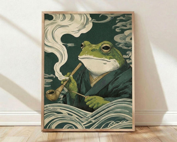 May include: Framed poster print featuring a green frog in traditional Japanese robes smoking a wooden pipe, rendered in classic ukiyo-e woodblock style with swirling clouds and stylized waves in teal and cream colors. The artwork is displayed in a light wood frame, leaning against a white wall on light wooden flooring with soft natural lighting and fabric shadows visible.
