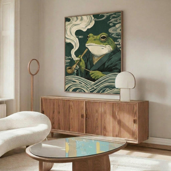May include: Japanese-inspired artwork featuring a green frog in traditional robes smoking a pipe, surrounded by stylized waves and clouds in teal and cream colors. The print hangs above a mid-century modern walnut credenza in a minimalist living room with white walls, accompanied by a curved white chair and glass-top coffee table.