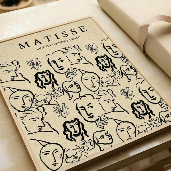 Beige art print featuring black line drawings in Matisse's style showing various human faces and botanical elements scattered across the surface. The minimalist illustrations include profile and frontal portraits with different hairstyles, some with curly dark hair, alongside simple leaf and plant motifs. The print sits on white paper with neutral fabric ribbon visible at the edges, photographed on a cream surface with soft natural lighting.