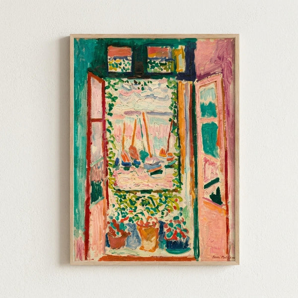 Colorful Fauve-style painting showing an open window view with sailboats on water, framed by green shutters and foliage. Vibrant brushstrokes in pink, orange, green, and blue create an interior scene looking out to a harbor. Potted plants sit on the windowsill. The artwork is displayed in a light wood frame against a white wall.
