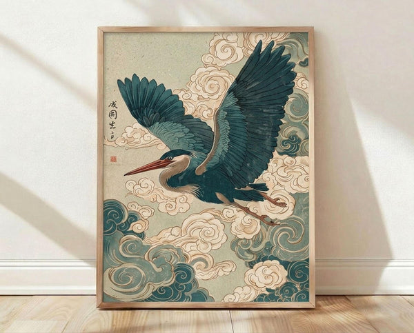 May include: Framed Japanese-style artwork featuring a blue-green heron with outstretched wings flying through swirling cream and teal clouds. The print has a vintage woodblock aesthetic with detailed feathers and decorative cloud patterns. Japanese characters appear in the upper left corner with a red seal stamp. The artwork is displayed in a light wood frame, leaning against a white wall on light wooden flooring with natural shadows casting across the scene.