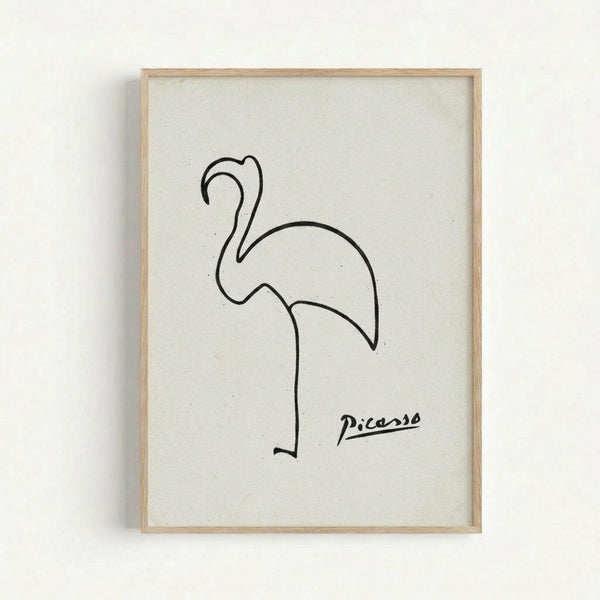 A minimalist line drawing of a flamingo rendered in black ink on white paper, displayed in a light wooden frame against a white wall. The artwork features simple, continuous curves that form the bird's distinctive S-shaped neck, rounded body, and single visible leg in Picasso's characteristic single-line style. The artist's signature appears in black script in the lower right corner.
