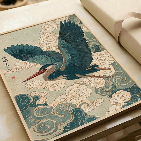 Japanese-style illustration of a blue-green heron in flight with outstretched wings, surrounded by swirling clouds in teal and cream colors. The artwork features traditional woodblock print aesthetics with detailed feather work and decorative cloud patterns. Print is displayed on white paper with rolled edges visible, photographed on a light wooden surface with soft natural lighting.