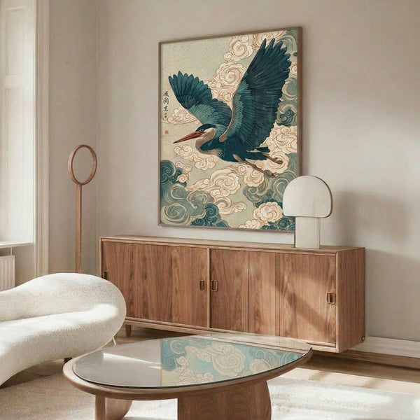 May include: Japanese-style artwork featuring a blue-green heron with outstretched wings flying through stylized clouds, displayed in a thin frame above a wooden sideboard. The print shows traditional Asian artistic elements with teal and cream colors. Modern living room setting with white curved chair, glass coffee table, and minimalist decor.