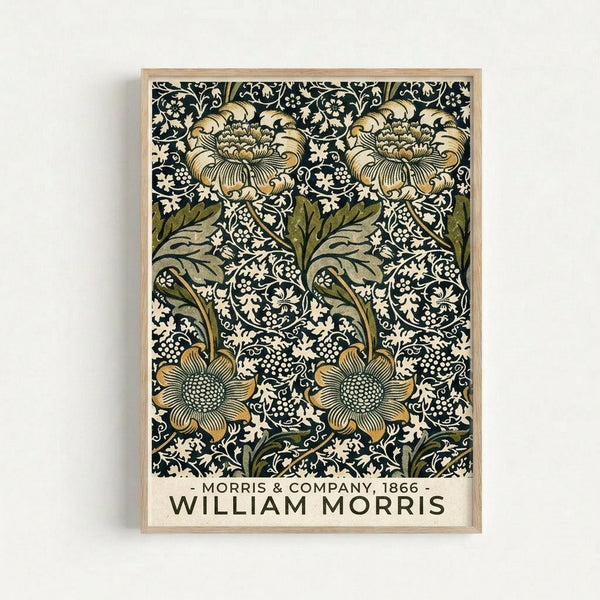 Vintage botanical wallpaper pattern featuring large ornate flowers with detailed petals and centers in golden yellow and cream tones, surrounded by dark green leaves and intricate white floral vines on a black background. The decorative design is displayed as a framed print with light wood frame against a white wall, showing the repeating Arts and Crafts movement style with flowing organic forms and rich contrasting colors.