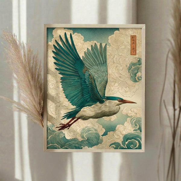 May include: Framed Japanese-style artwork depicting a blue-green heron in flight with outstretched wings soaring through stylized cream and teal clouds. The print features traditional ukiyo-e inspired waves and swirling cloud patterns with a red text cartouche in the upper right corner. Displayed in a light wooden frame on a neutral wall beside dried pampas grass stems and flowing curtains in soft natural lighting.