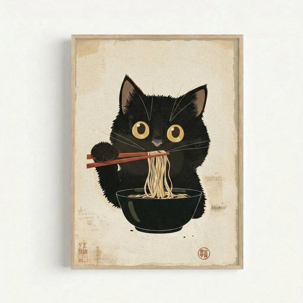 Framed artwork showing a black kitten with large golden eyes using chopsticks to eat noodles from a dark bowl. The illustration is done in traditional Japanese ukiyo-e woodblock print style on aged, cream-colored paper with visible texture and staining. Red Japanese characters and seals appear in the bottom corners. The piece is displayed in a simple light wood frame against a white wall.