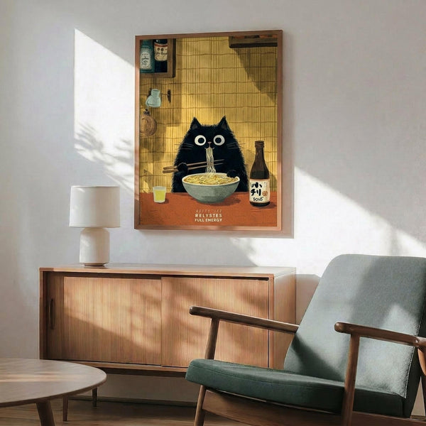 May include: Framed poster showing a black cat with wide white eyes eating ramen noodles from a bowl, set in a Japanese kitchen with bamboo mat background and sake bottle. Wooden credenza below holds white ceramic table lamp. Mid-century modern sage green armchair with wooden frame sits beside round coffee table. Bright natural light streams across white wall creating geometric shadows.