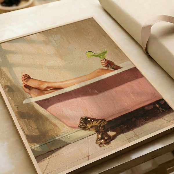 A vintage-style poster print showing a person relaxing in a pink bathtub, holding a green margarita glass, with bare legs visible over the tub edge. A tabby cat sits on the bathroom floor nearby. The artwork has warm, muted tones with painterly brush strokes and is displayed as a flat print on white paper with cream ribbon visible in the corner.