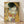 May include: Framed reproduction of Klimt's famous golden painting showing an embracing couple against ornate patterned background with geometric shapes and colorful circles, displayed in light wood frame leaning against white wall on wooden floor.