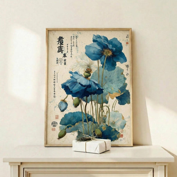 May include: Framed botanical artwork featuring blue poppies with oriental calligraphy text, displayed on a light wood shelf against a cream wall. The vintage-style print shows detailed watercolor flowers in various shades of blue with green stems and seed pods. A small white wrapped gift sits in front of the thin wooden frame.
