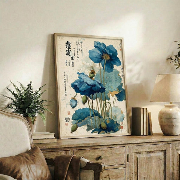 May include: Framed botanical artwork featuring blue poppies with Oriental calligraphy displayed on a rustic wooden sideboard alongside books, ceramic vases, and a fern plant in a neutral-toned living room setting with beige chair visible in foreground