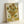 May include: Framed reproduction of Van Gogh's famous sunflowers painting leaning against white wall. The artwork shows vibrant yellow sunflowers in various stages of bloom arranged in a ceramic vase, painted in Van Gogh's distinctive thick brushstroke style with golden yellow background. Natural wood frame surrounds the textured print.