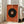 May include: Large framed abstract art print leaning against white wall next to beige sofa in bright living room. Orange textured background with large black circle containing smaller concentric circles in orange, blue and yellow. Thin colored lines extend from center like rays. Natural light from tall windows creates soft shadows on hardwood floor.