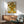 May include: Van Gogh's Sunflowers painting reproduction in wooden frame hanging above mid-century modern wood credenza with white ceramic lamp. Sage green upholstered armchair with wooden arms sits nearby. Bright sunlight casts dramatic shadows across white wall in minimalist living room setting.
