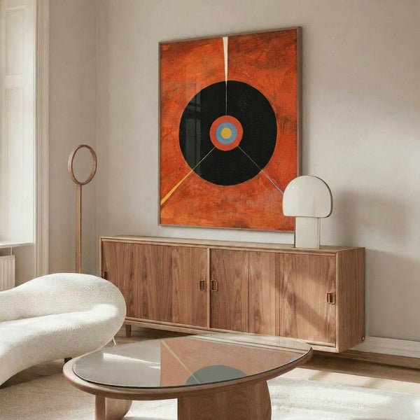 May include: Abstract art print with orange background and large black circle containing concentric colored rings in blue and yellow, displayed above walnut credenza in modern living room with white curved chair, brass floor lamp, and round glass coffee table